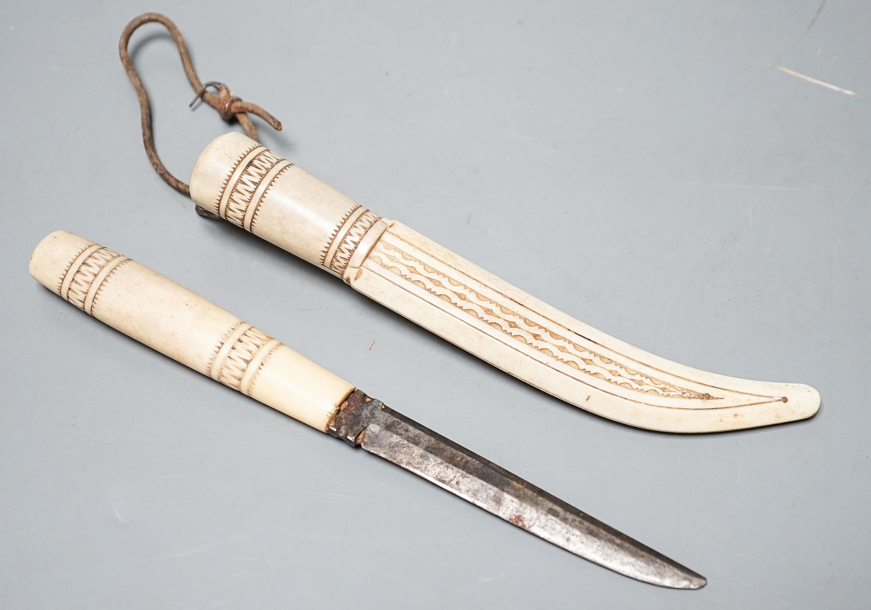 A 19th century Inuit carved stag antler dagger and scabbard, initialled ‘K.E’.